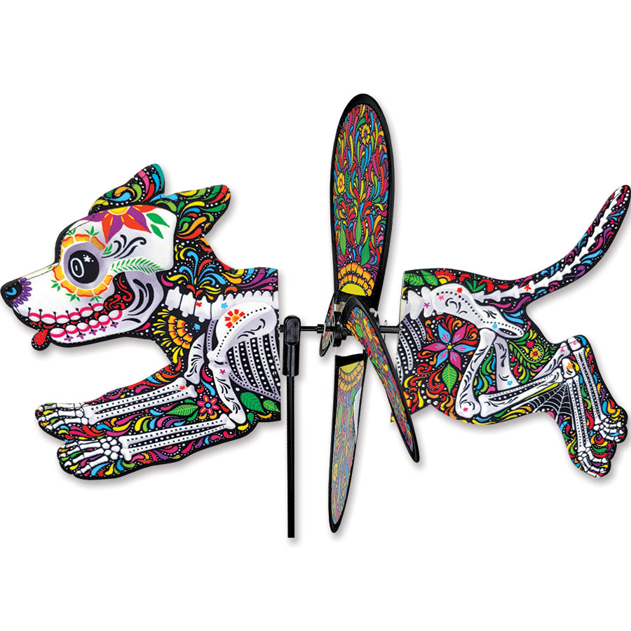 Petite Spinner featuring a colorful Day of the Dead Dog design, spinning gently in an outdoor garden setting surrounded by greenery.