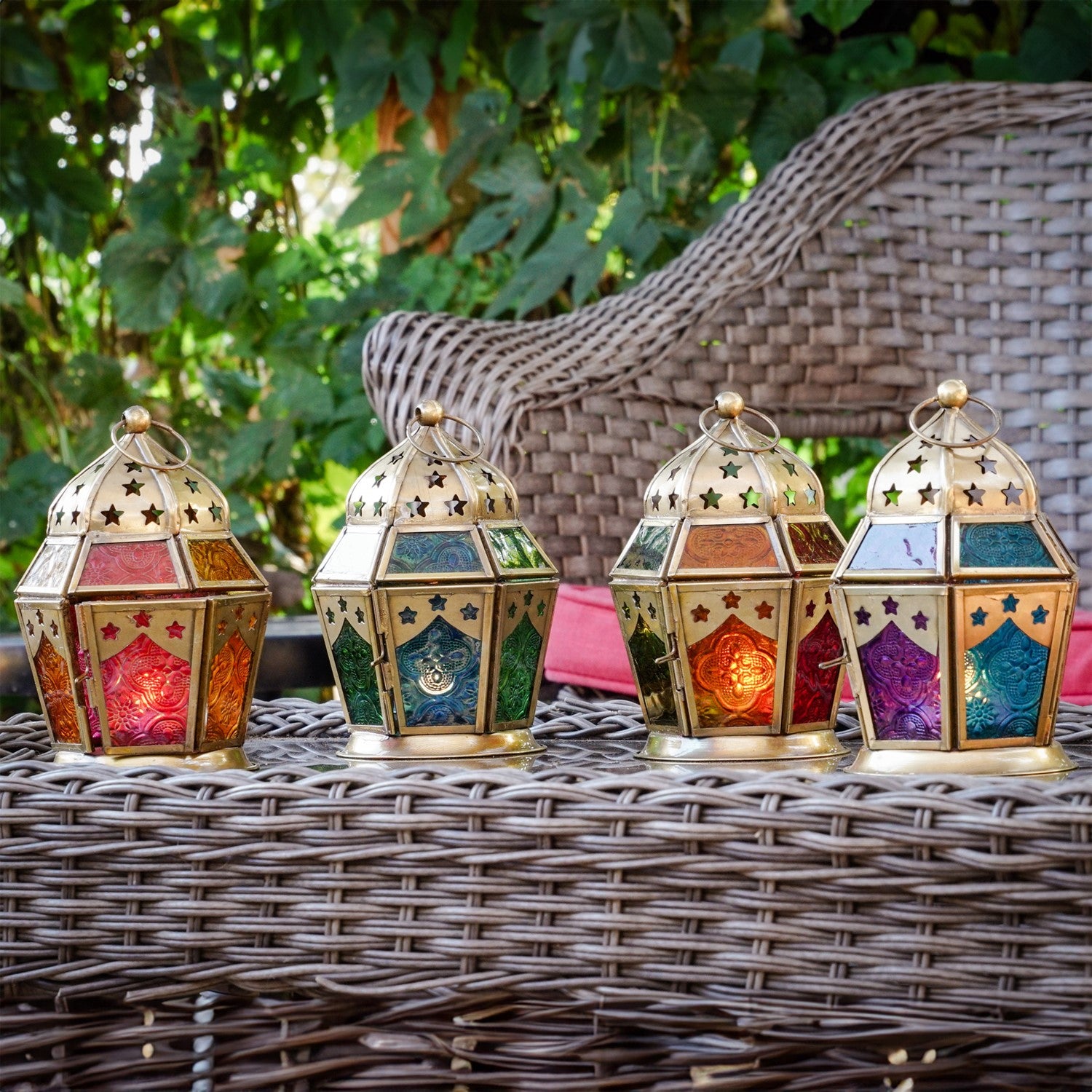 Pink and yellow hex glass tealight lantern with stamped designs and metal frame, elegantly displaying a tealight candle in a cozy setup.