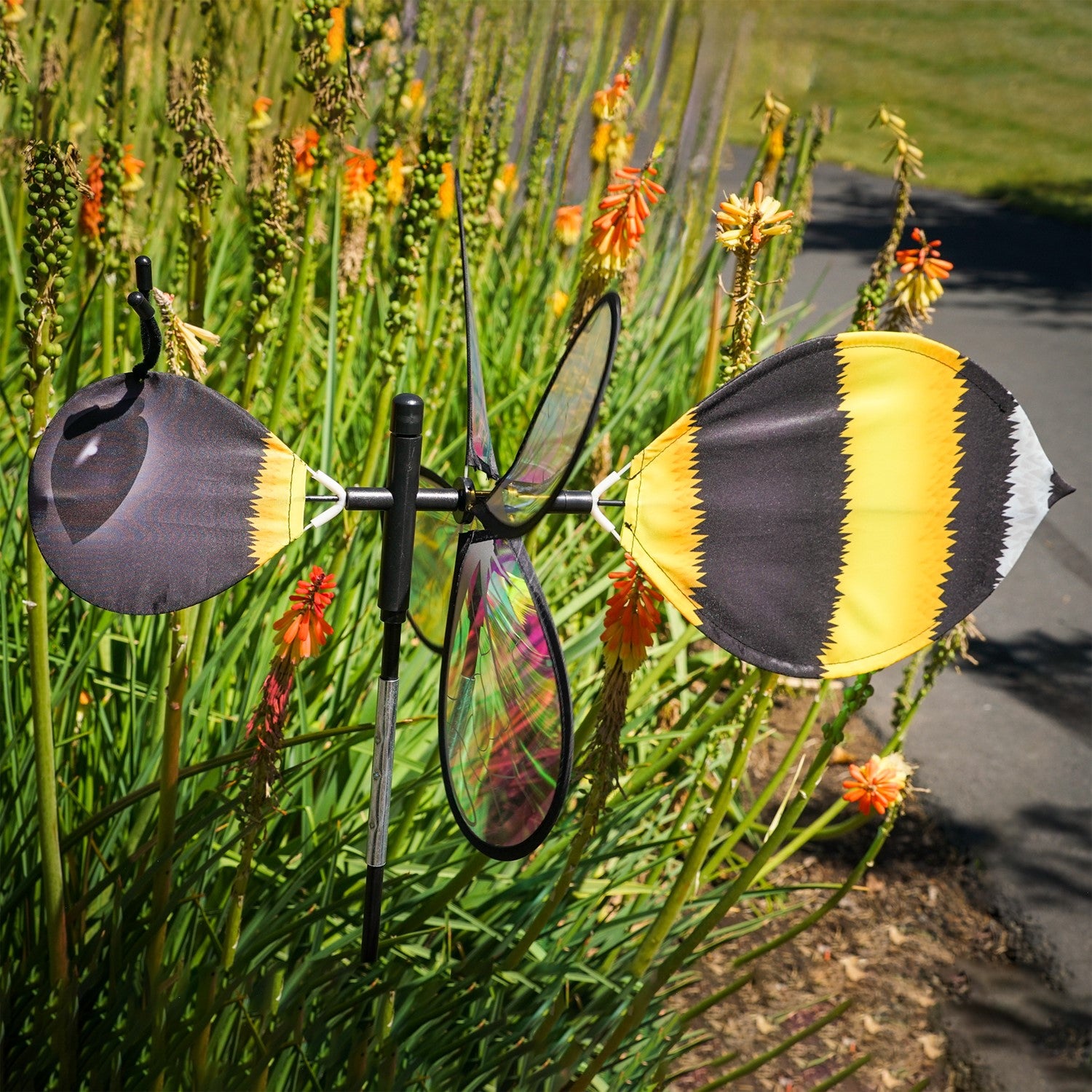 Pivoting Bumble Bee Bug Spinner with vibrant bumble bee design and iridescent wings displayed in an outdoor garden setting, spinning in the wind.