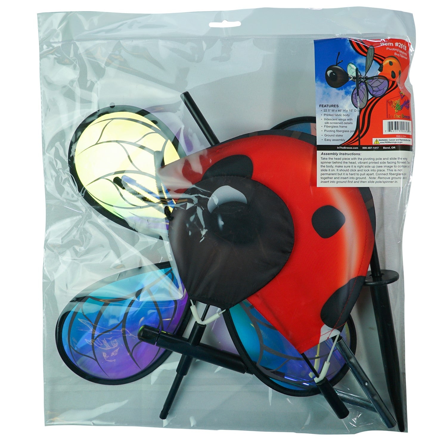 Pivoting Ladybug Spinner with vibrant design and iridescent petals spinning in a sunny garden setting, mounted on a sturdy pole.