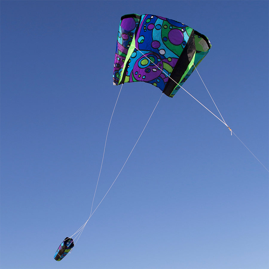 Power Sled 10 Kite - Cool Orbit flying in the sky, showcasing its vibrant design with a backdrop of blue clouds.