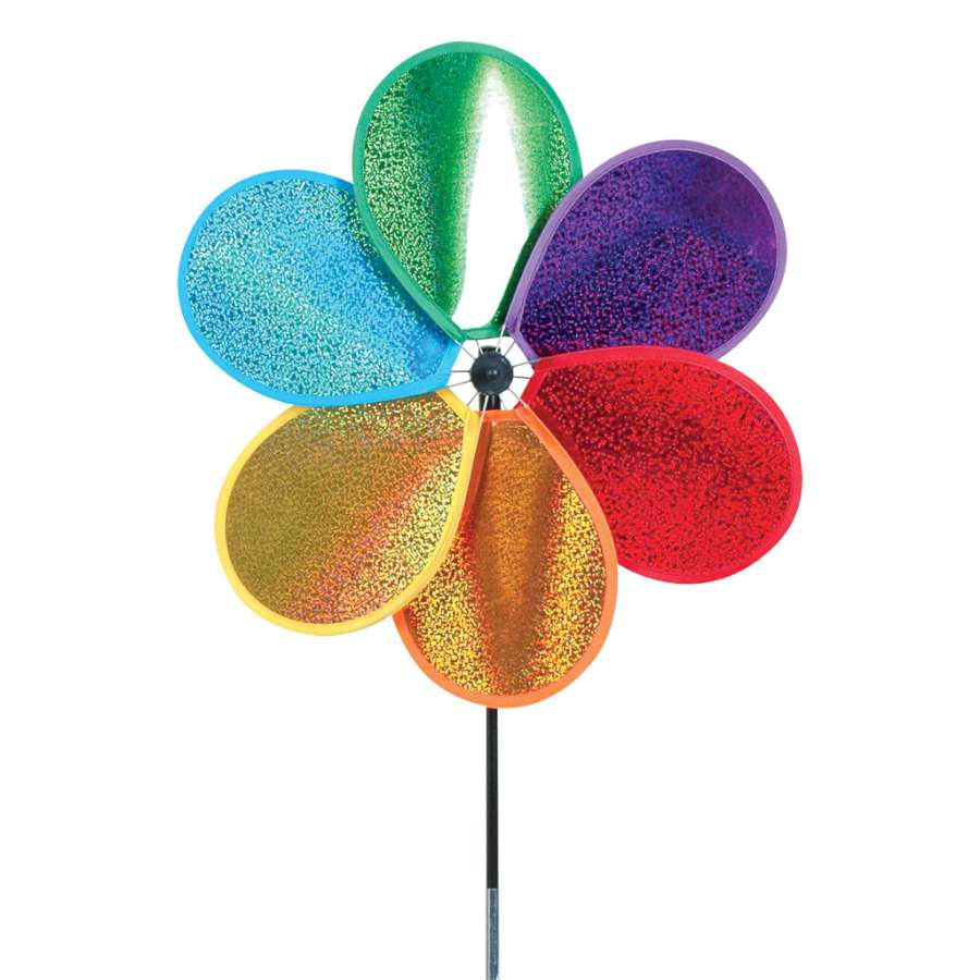 Prismatic Large Daisy Spinner with six holographic petals spinning in the breeze, showcasing a rainbow of colors in an outdoor garden setting.