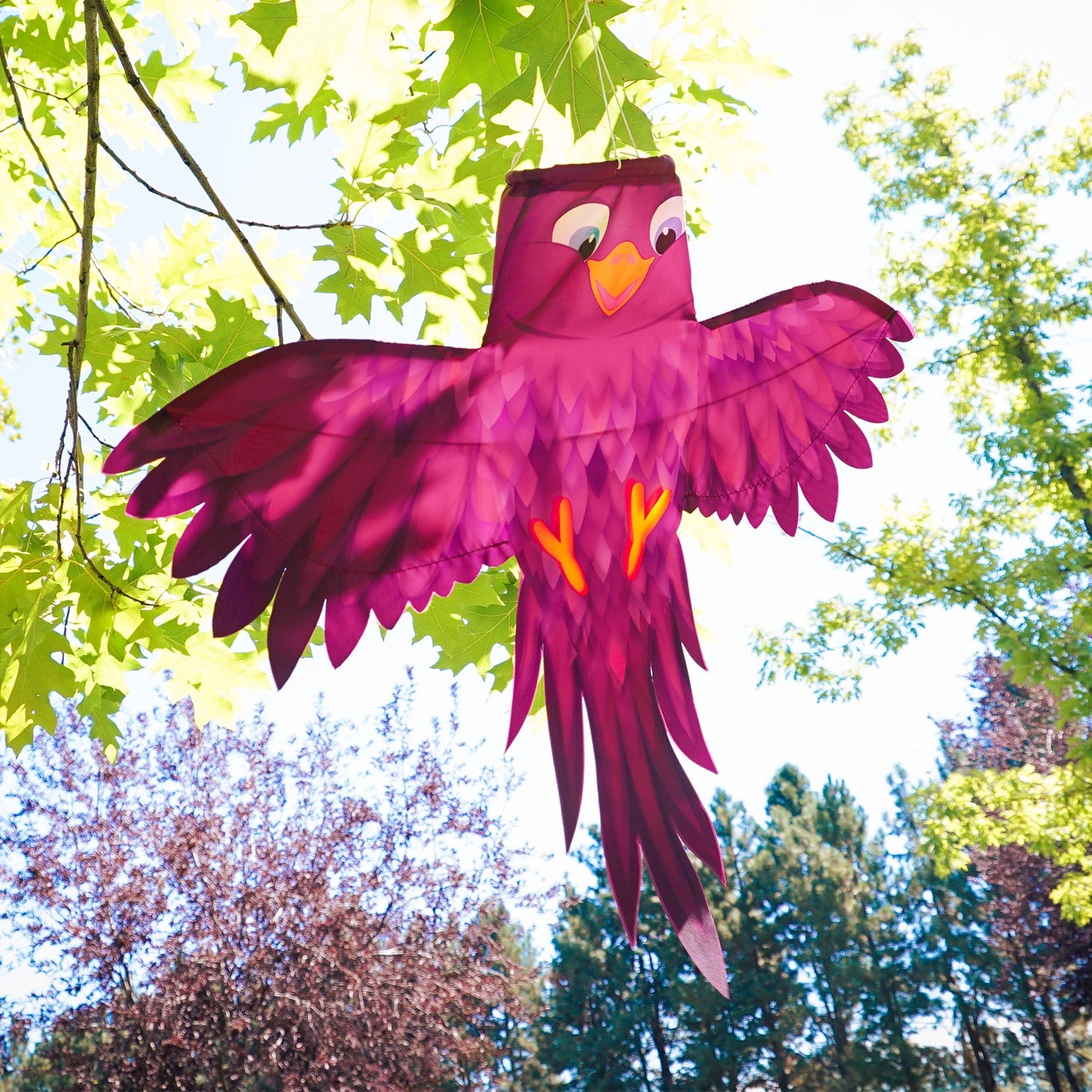 Colorful Purple Bird Windsock with spread wings fluttering in a gentle breeze, showcasing vibrant purple hues in an outdoor setting.
