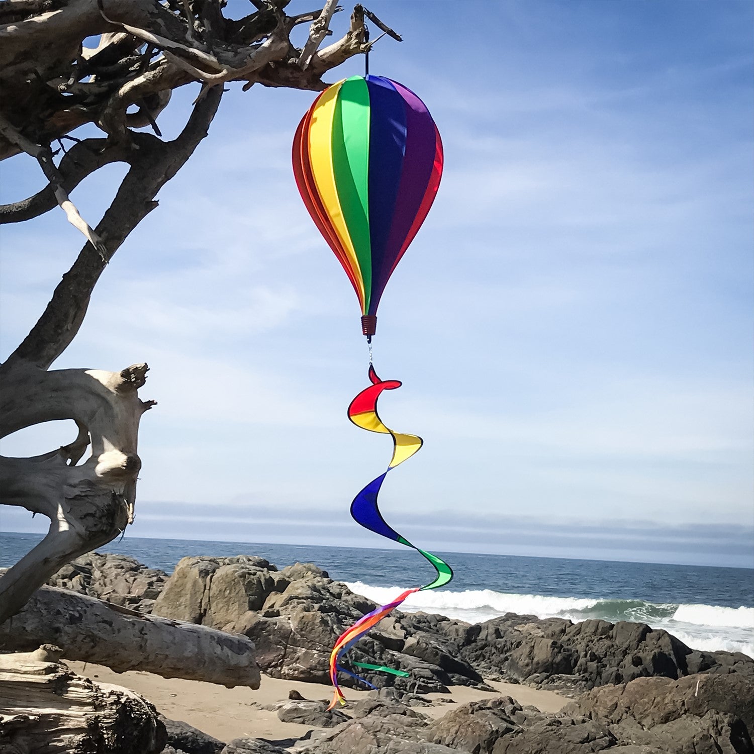Vibrant Rainbow 12-Panel Hot Air Balloon spinner in a garden setting, showcasing colorful panels and twister tail spinning gracefully.