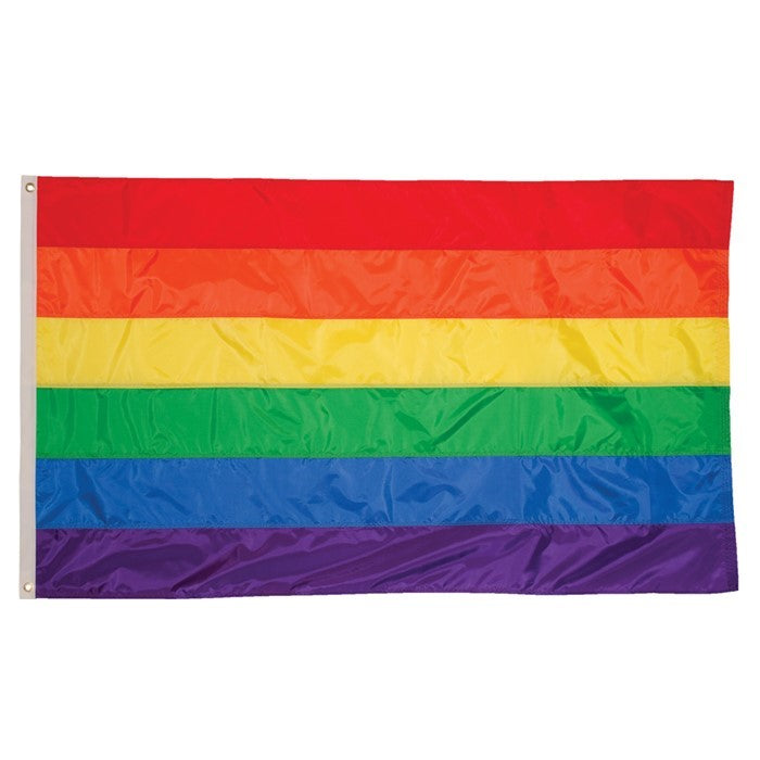 Rainbow 3x5 Grommet Flag featuring bright colors and brass grommets displayed on an outdoor flag pole against a clear blue sky.