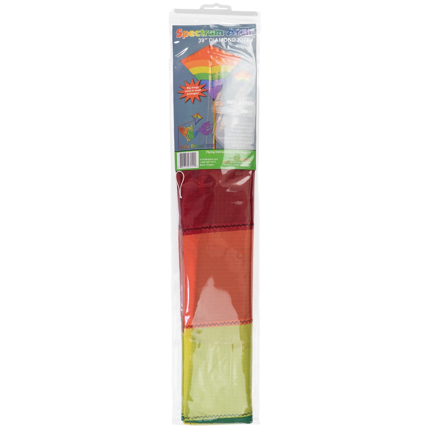 Rainbow Arch 39-Inch Diamond Kite in vibrant colors, featuring long fabric tails, soaring against a bright blue sky on a sunny day.
