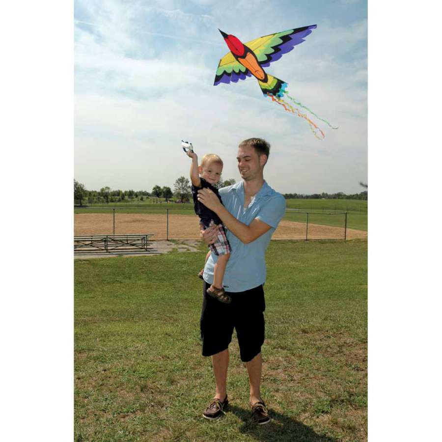 Rainbow Bird Kite measuring 70x36 inches, showcasing bright colors and detailed applique work, displayed against a clear blue sky.