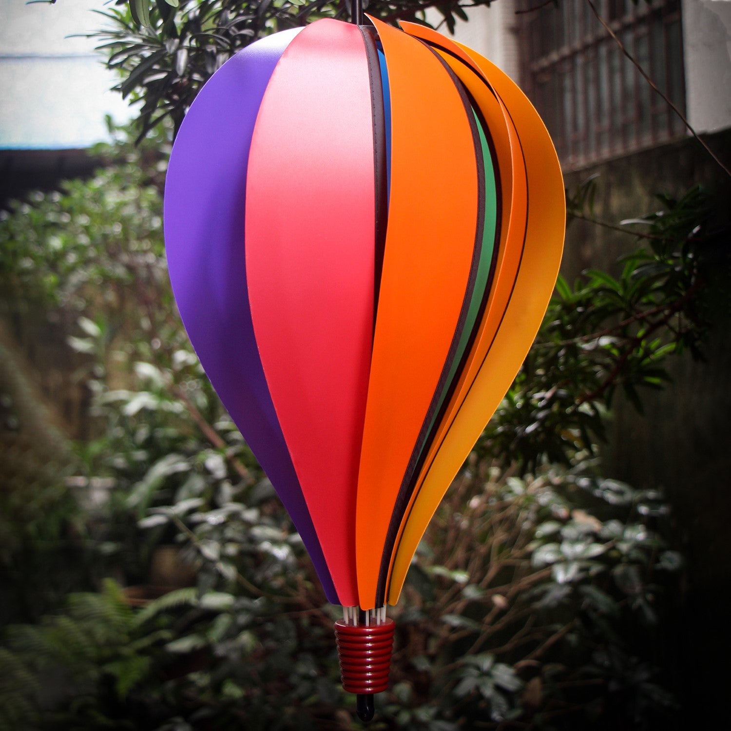 Rainbow Poly 10-Panel Hot Air Balloon spinner showcasing colorful panels in a garden setting, gently spinning in the breeze.
