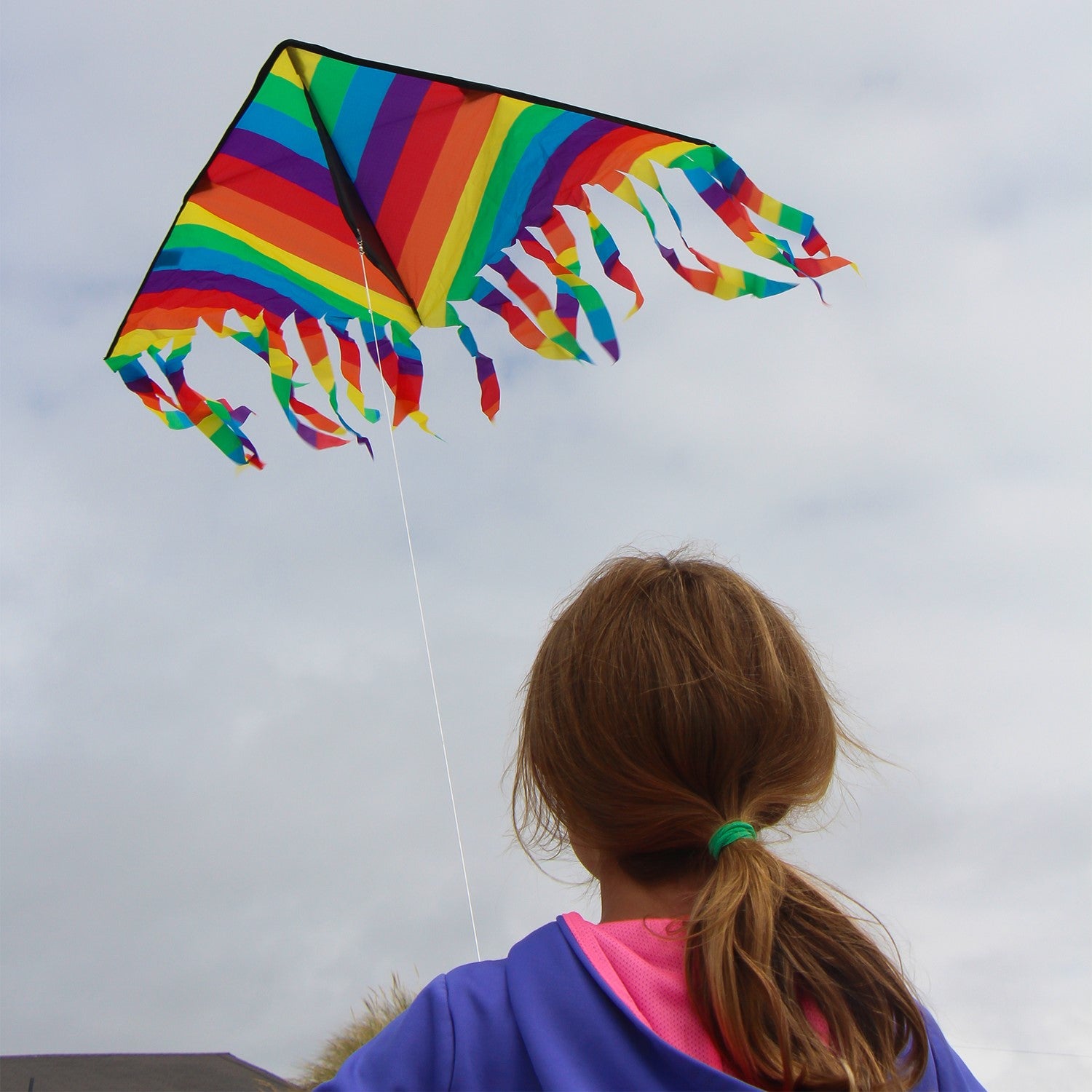 Rainbow Stripe 43" Flutterfly Delta kite soaring in the sky with colorful fluttering tails, perfect for outdoor fun and family activities.