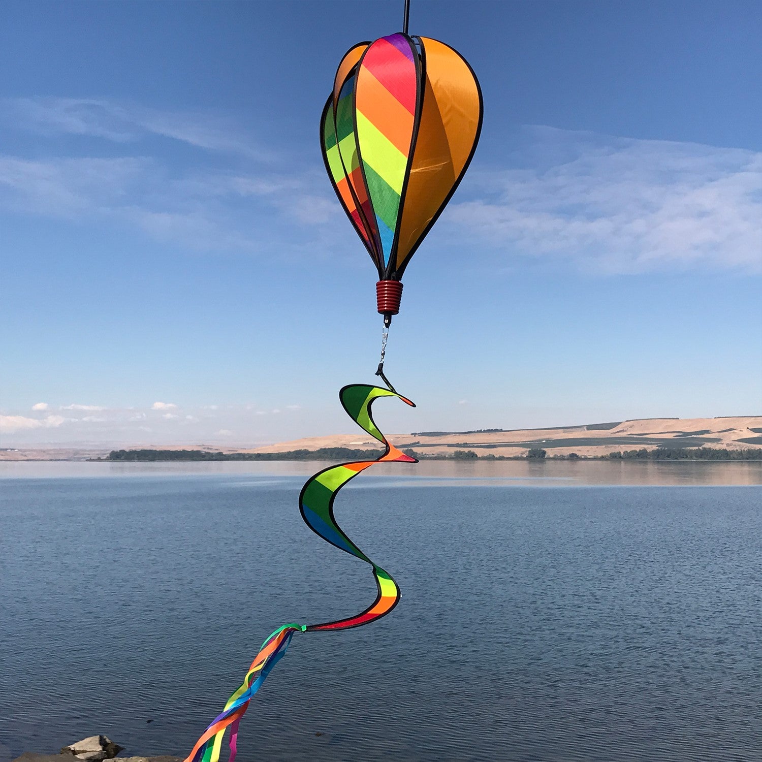 Rainbow Striped Hot Air Balloon spinner in vibrant colors with alternating rainbow and solid striped design, spinning under outdoor sunshine.