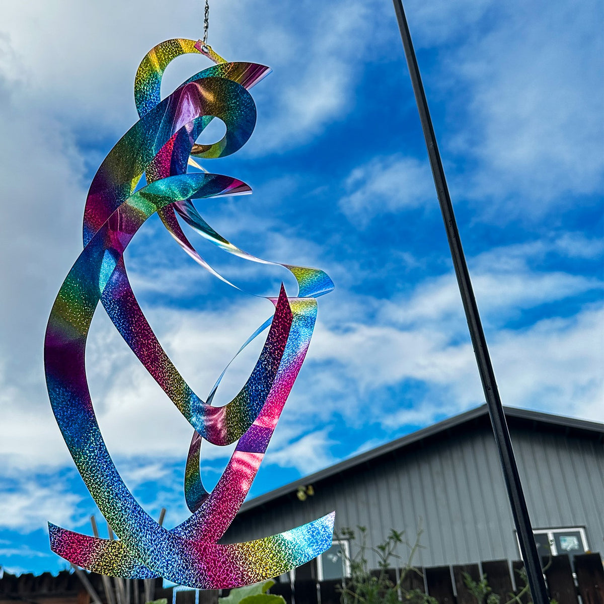 The Rainbow Whirl Mylar Spin Quartet is a stunning hanging decor featuring vibrant mylar curls that shimmer in the sunlight, ideal for outdoor festivities and gardens.