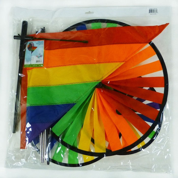 Rainbow Wind Sail Triple Wheel Spinner showcasing three spinning wheels in a rainbow spectrum, set against a clear blue sky with a pivoting pole for wind display.