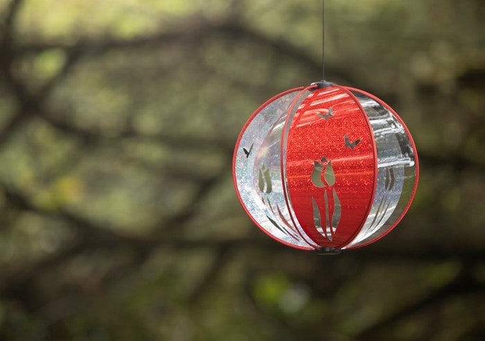 Red Tulip Spinning Globe measuring 11x10 inches with six vibrant poly panels, showcasing a beautiful tulip design, hanging in an outdoor space.