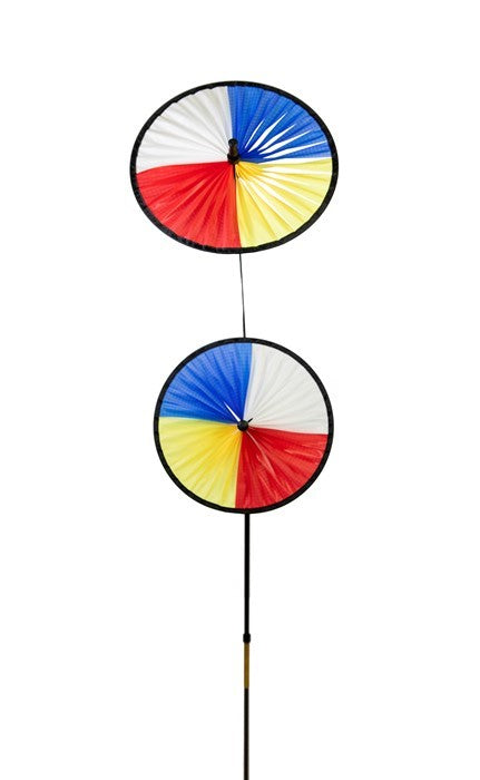 Red, Yellow, Blue & White Space Flower Ground Spinner in motion, featuring two colorful wheels on a sturdy pole in a garden setting.