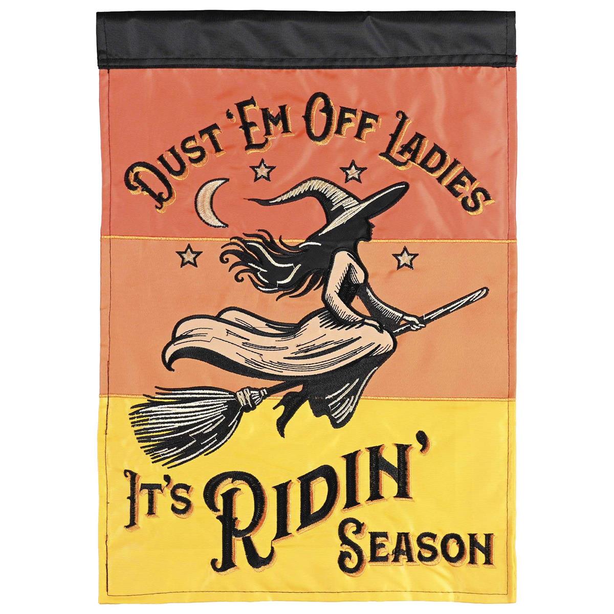 Double-sided Riding Season Witch Broom garden flag featuring vibrant colors and detailed embroidery, displayed in a garden setting for Halloween decor.
