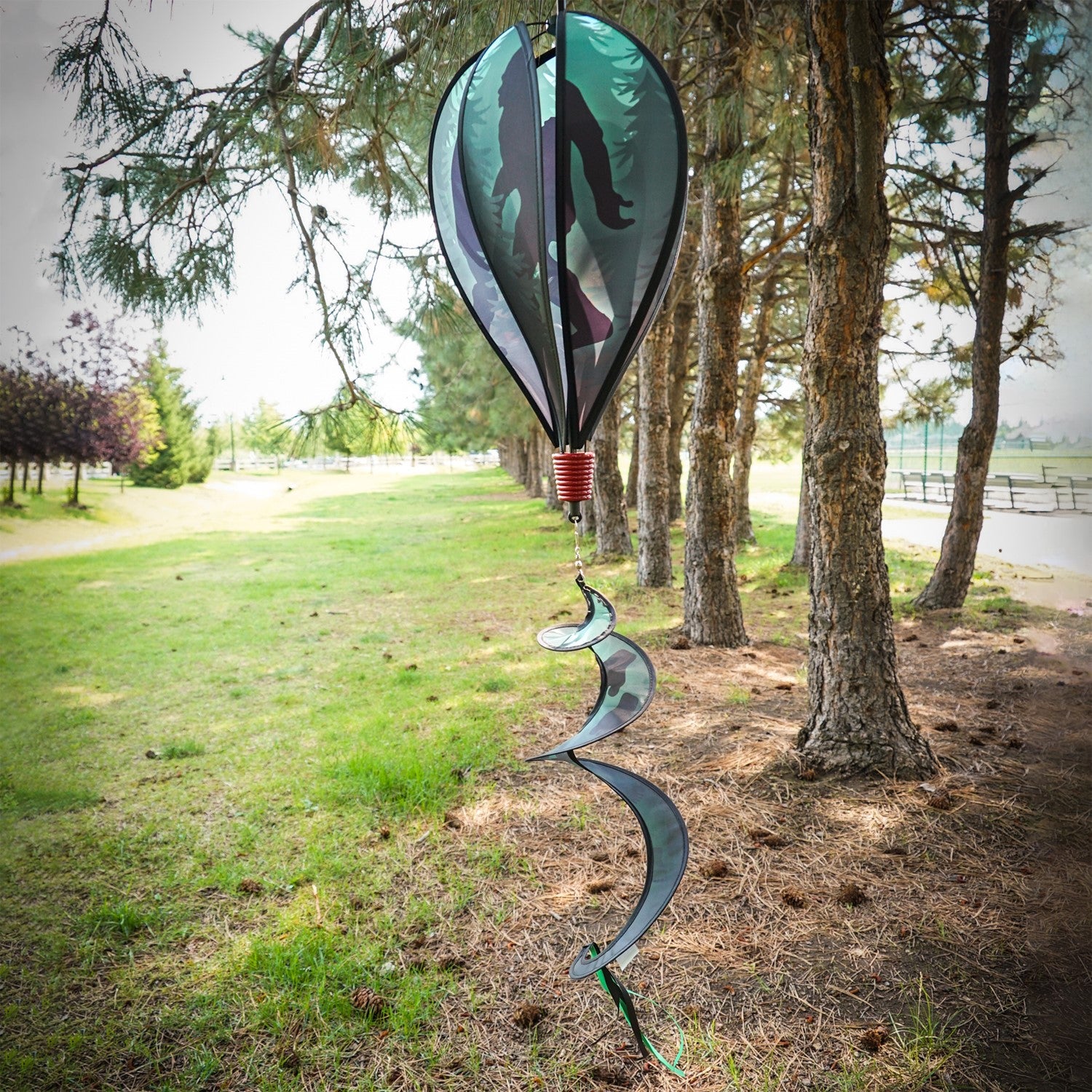 Sasquatch 6-Panel Hot Air Balloon spinner featuring colorful panels and streamers, elegantly displayed in an outdoor garden setting.