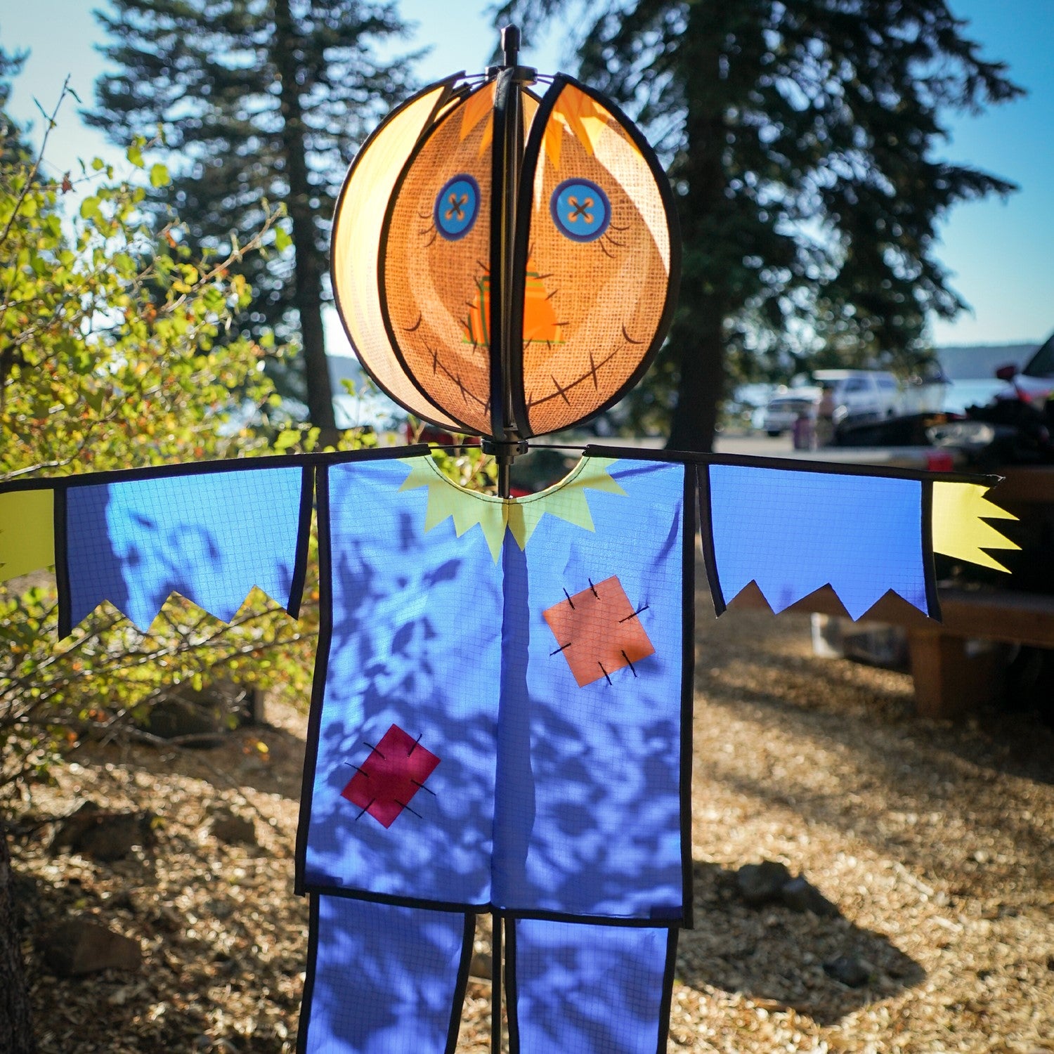 Colorful Scarecrow Ground Ball Spinner spinning in a garden setting, showcasing a friendly face with vibrant colors and durable design.