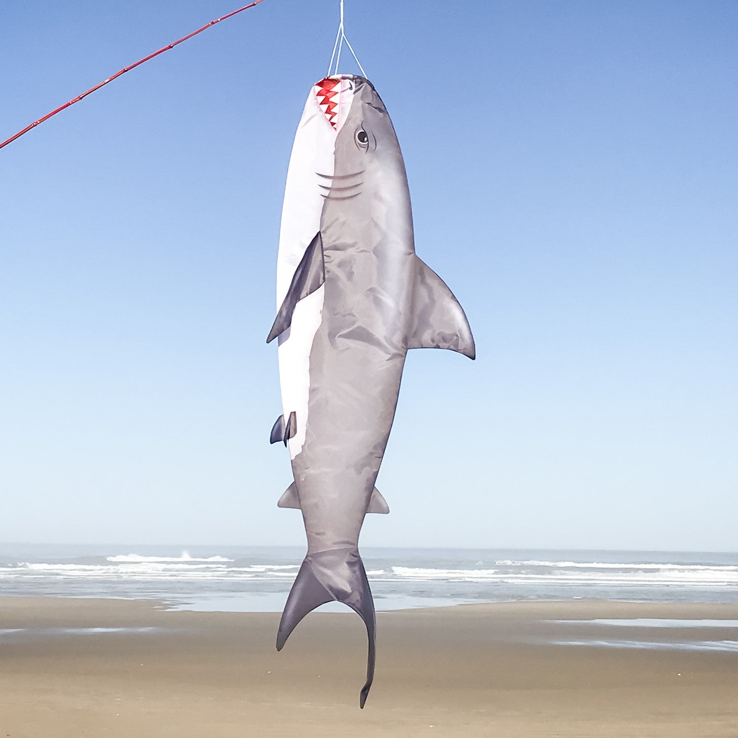 Shark 48" Fish Windsock featuring a realistic great white shark design, elegantly displayed in a backyard setting near the water.
