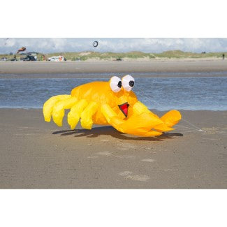 Yellow inflatable crab toy on a beach