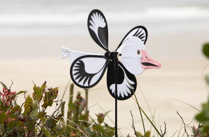 Snow Goose Baby Spinner in vibrant colors, featuring a baby snow goose design, spinning gracefully on a fiberglass pole in a garden setting.