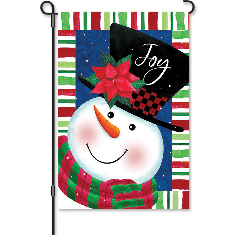 12 in. Snowman Joy garden flag featuring a cheerful snowman with a 'Welcome Friends' message displayed in a winter garden setting.