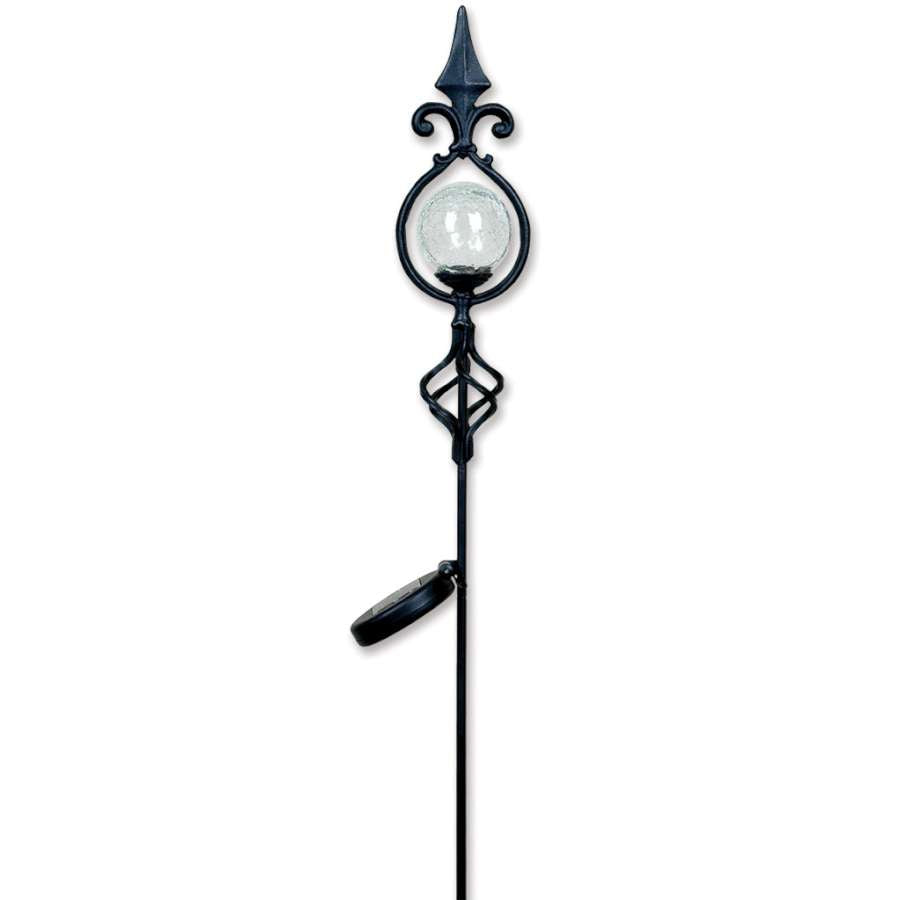 Solar Globes - Fleur De Lis in a garden setting glowing with transitional colors at dusk, showcasing their elegant design as night descends.