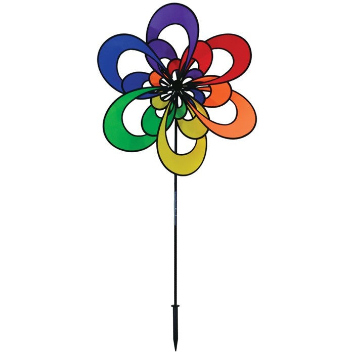 Spectrum Triple Windee Wheelz colorful garden spinner featuring three rotating rainbow flowers, displayed outdoors in a sunny garden setting.