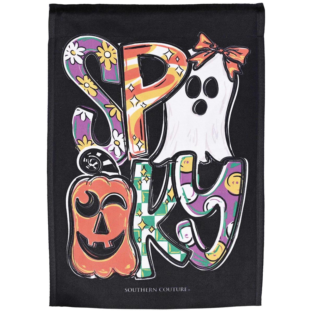 Spooky Garden Flag featuring whimsical Halloween design displayed in a garden, illuminated by sunlight for a stained glass effect.