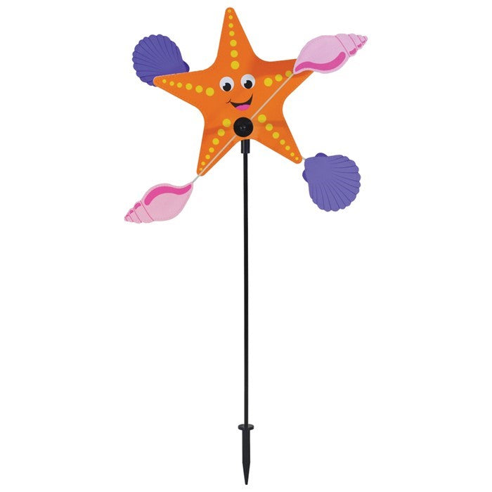 Starfish Whirligig featuring a colorful starfish design spins gracefully in the breeze, set against a vibrant outdoor garden backdrop, enhancing seaside charm.
