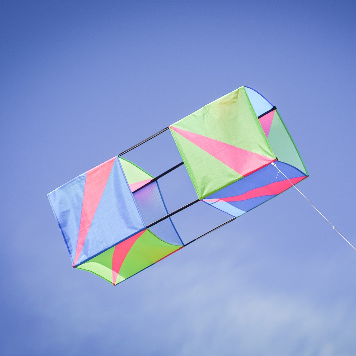 The Strike Double Box Kite soaring in the sky, showcasing its vibrant design and multiple sail surfaces for enhanced stability.
