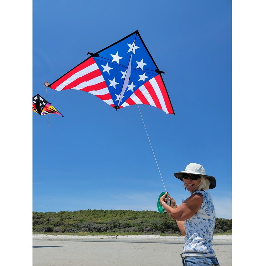 Sweet 16 Delta kite measuring 192 x 96 inches, displaying vibrant patriotic colors against a clear blue sky during a sunny day.
