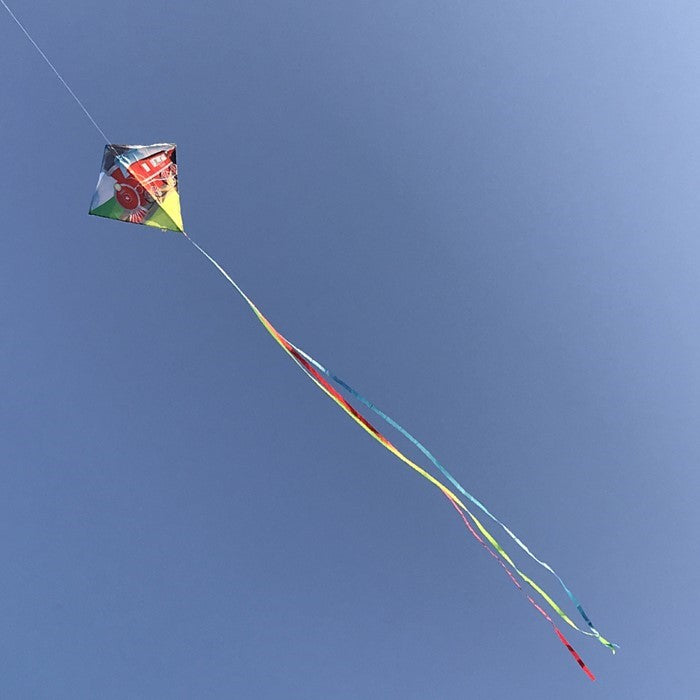 Train 30" Diamond Kite soaring in the sky with steam engine design and colorful tails, delighting children during an outdoor adventure.