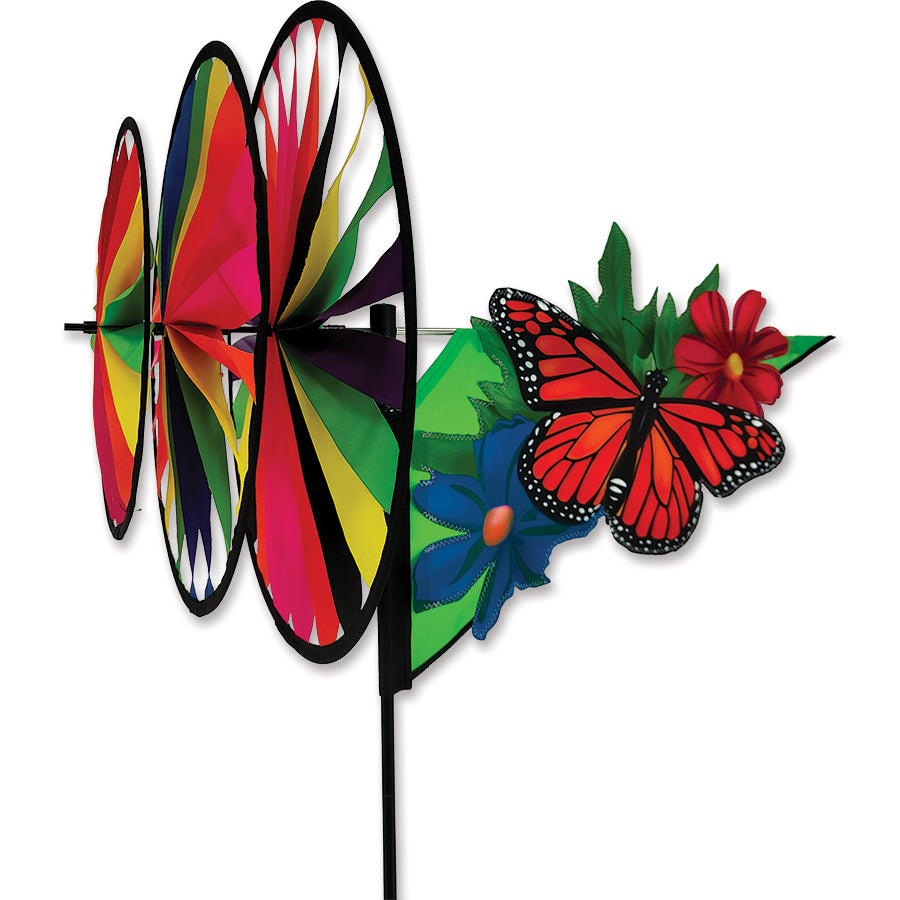 Triple Spinner - Monarch Butterfly with vivid colors spinning gracefully in a garden, showcasing its fade-resistant SunTex fabric in bright sunlight.