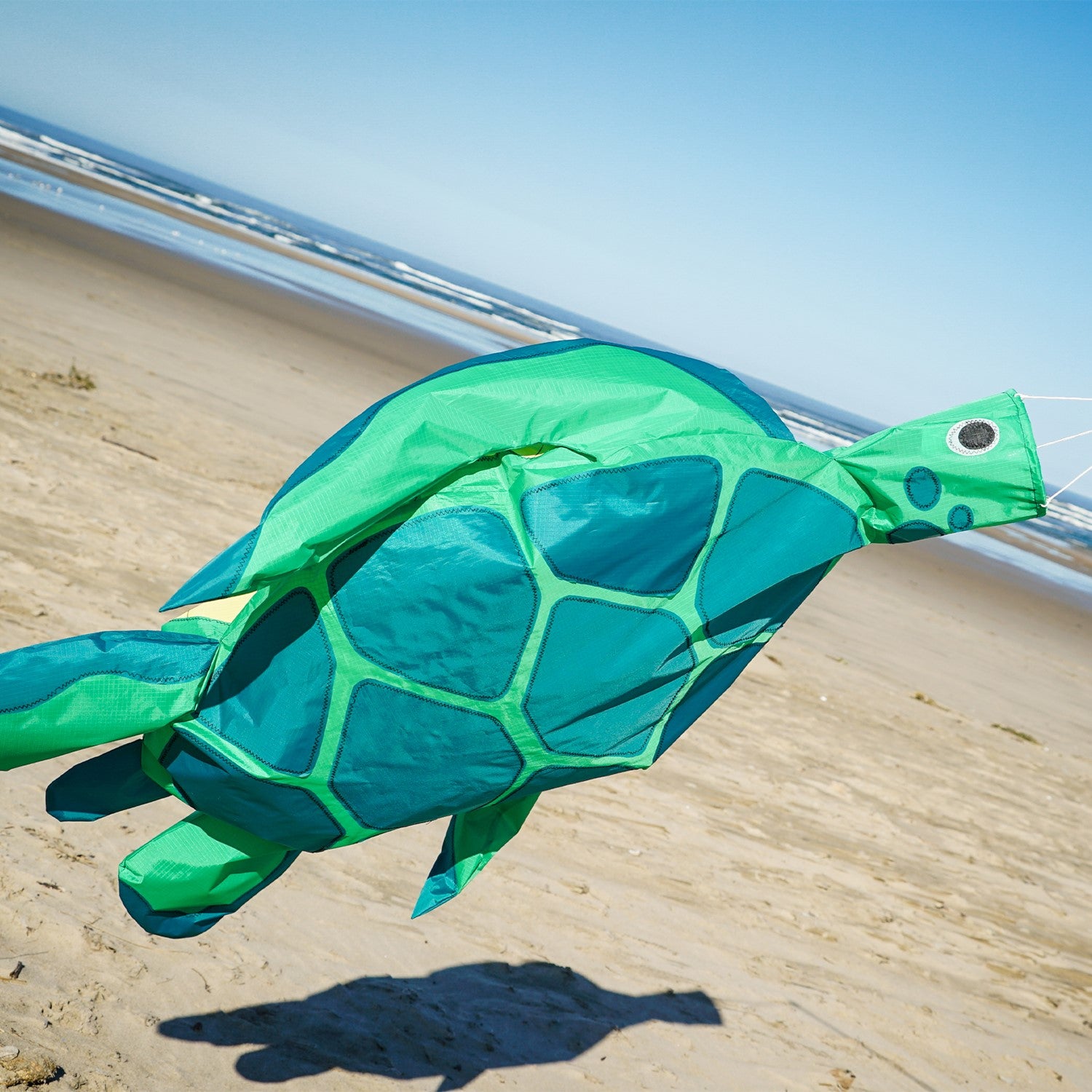 Turtle Big Breeze WindsockTM with 3D features, vibrant colors, and inflatable flippers displayed outdoors, gracefully waving in the wind.