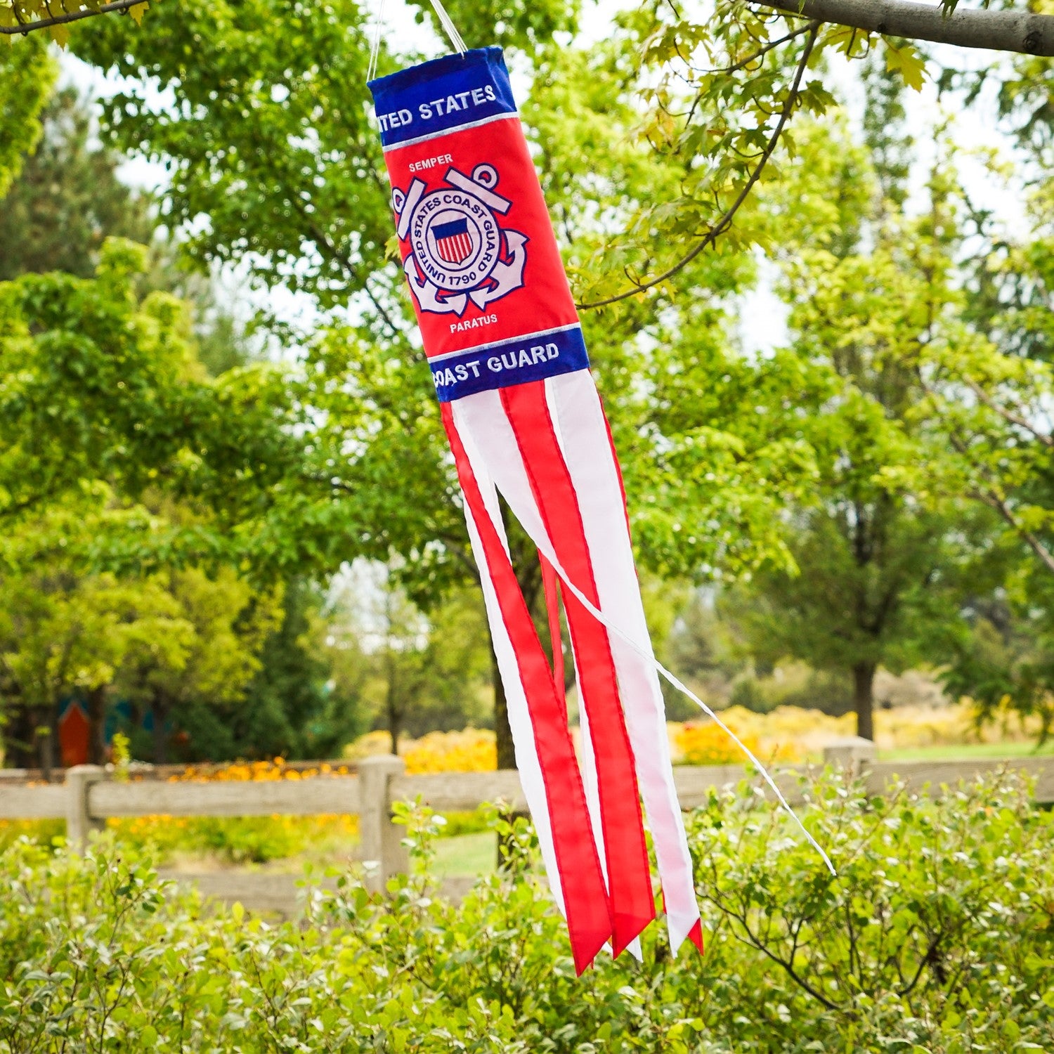 U.S. Coast Guard 40 inch windsock with detailed appliqued graphics and embroidered accents, fluttering outdoors in a garden setting.