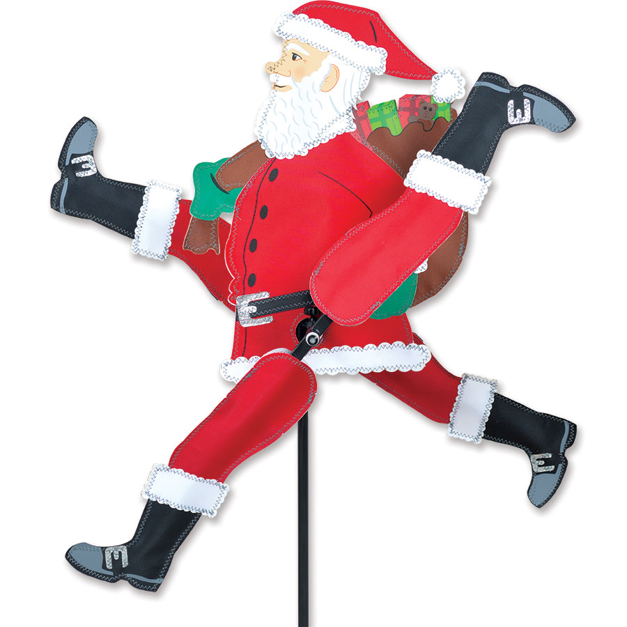 WhirliGig Spinner - Running Santa in vibrant colors spins in the breeze, adding a festive touch to an outdoor garden setting.