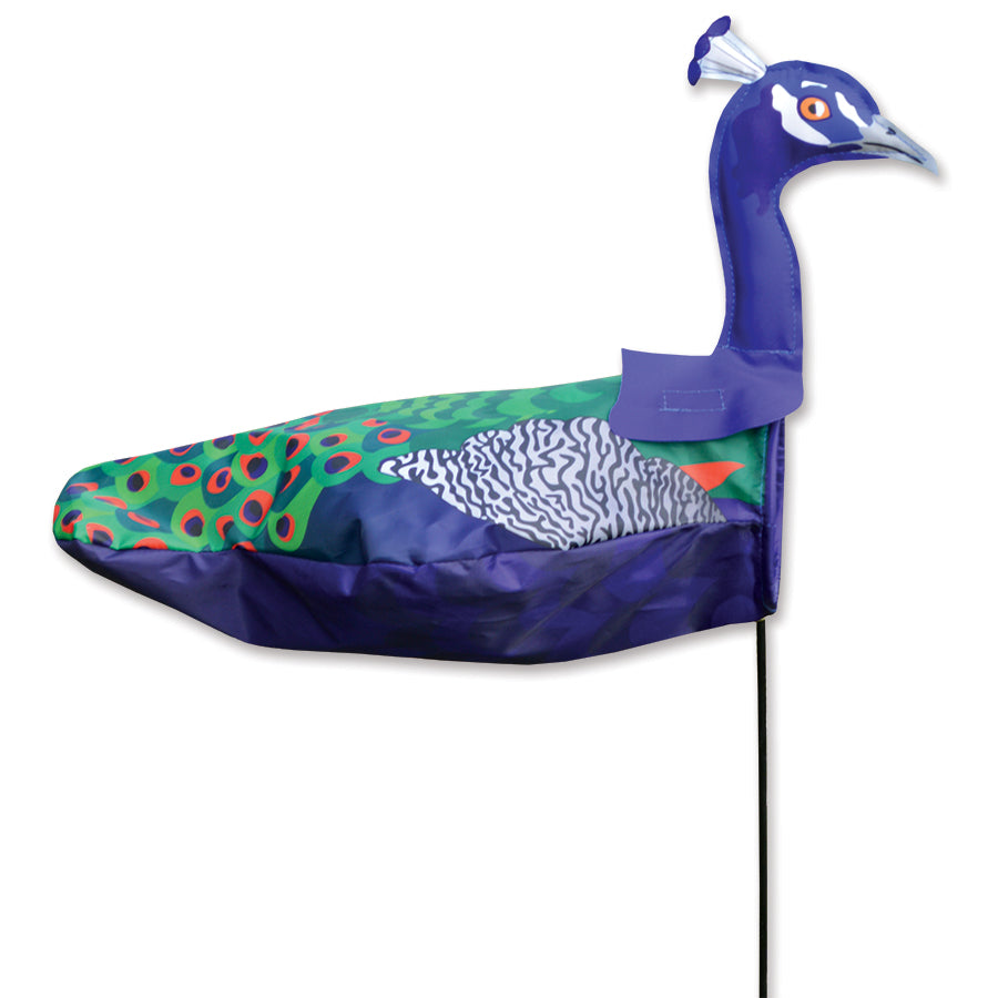 Windicator - Peacock weather vane standing tall with vibrant colors in a garden, showcasing its unique design and playful presence in motion.