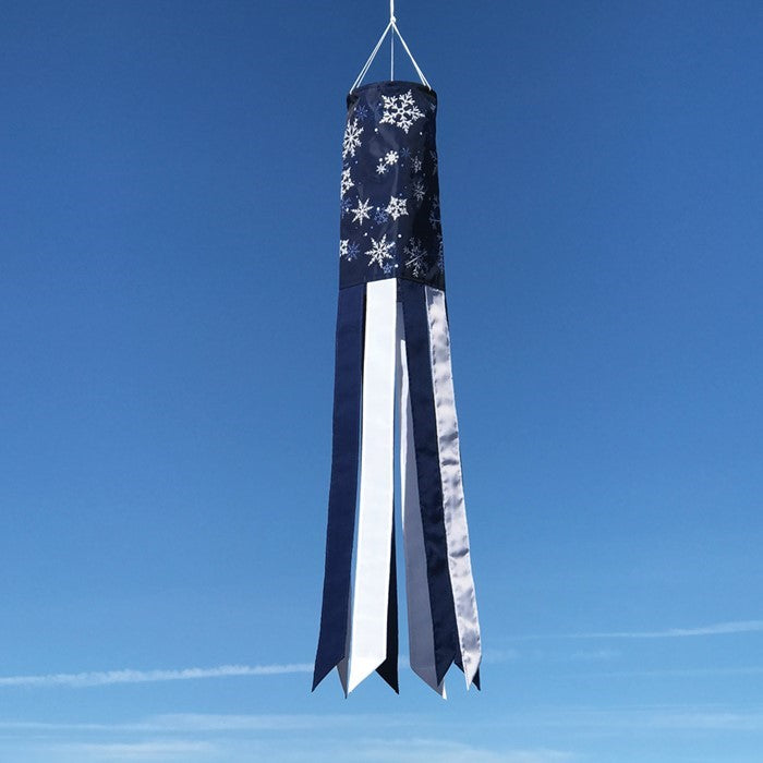Winter Wonderland 40-inch windsock featuring a snowflake design in blue and white, gently fluttering outdoors in the winter breeze.