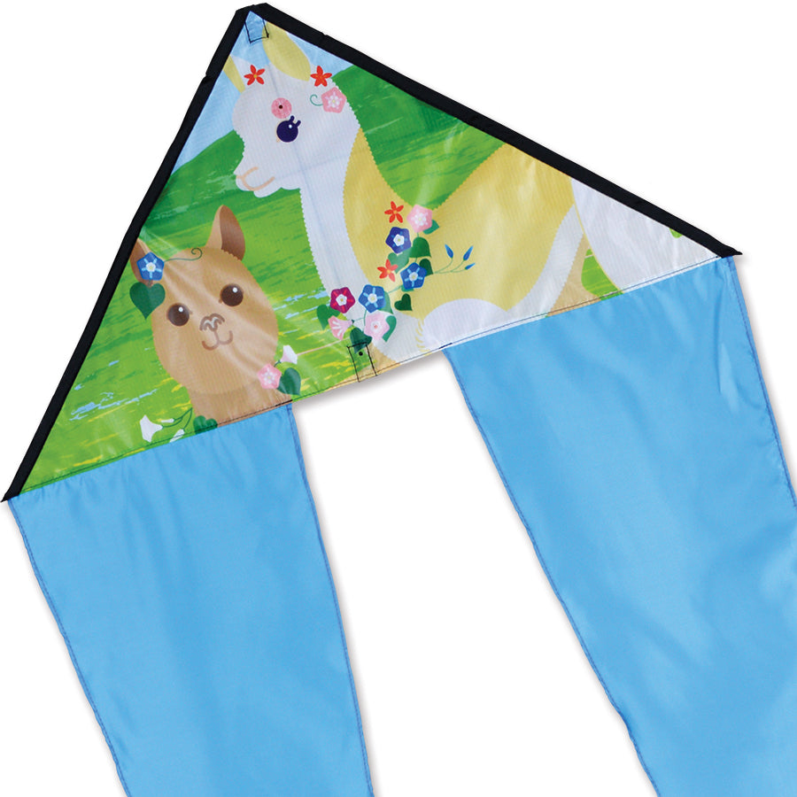 Zippy Flo-Tail Delta Kite with a colorful alpaca design flying against a bright blue sky, showcasing its long, flowing tail.