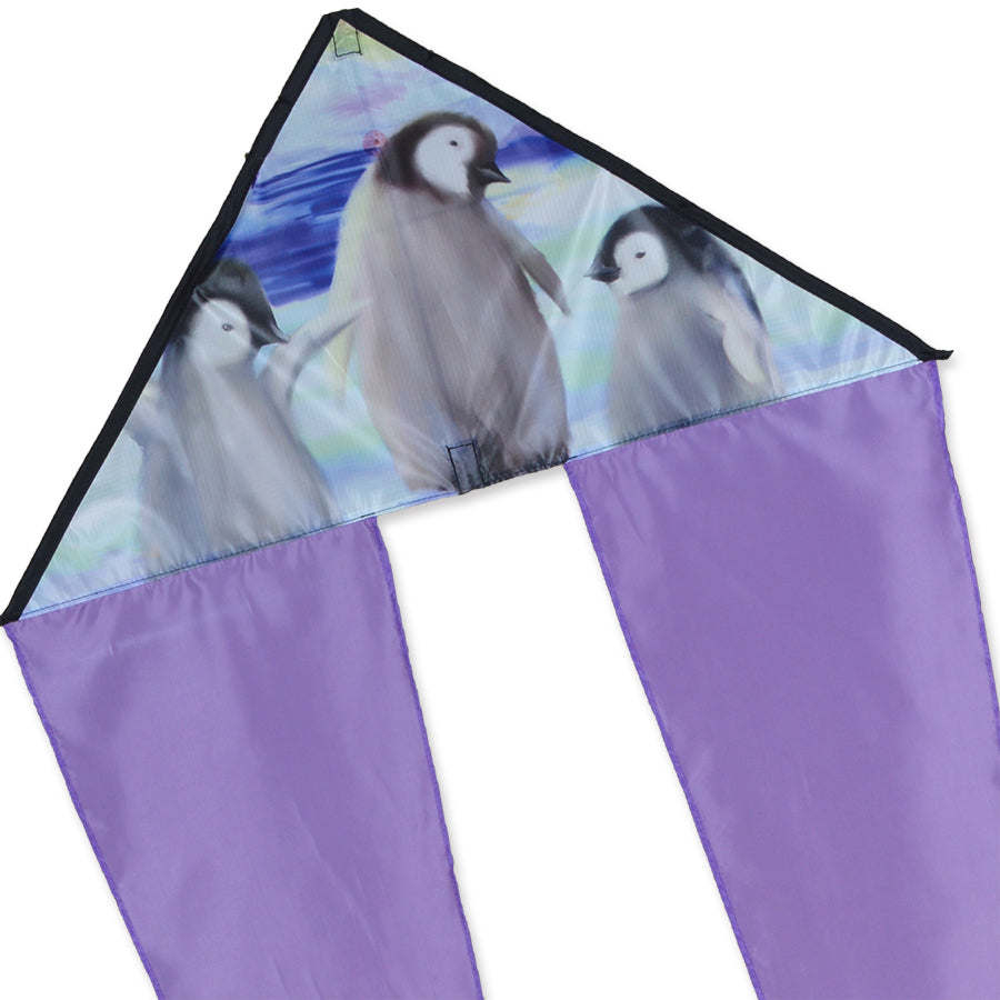 Zippy Flo-Tail Delta Kite featuring penguin design, soaring high in the sky, showcasing long colorful tails against a blue backdrop.
