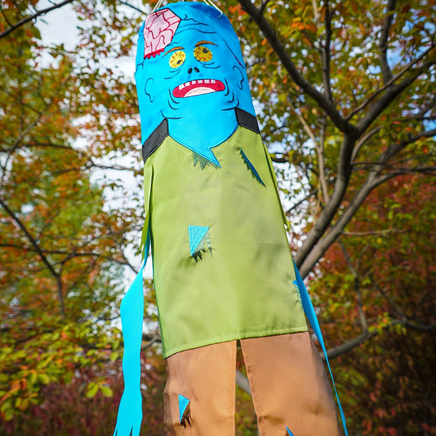 Colorful Zombie 40" Breeze Buddy Halloween decoration with free-flowing arms and legs, displayed outdoors swaying in the breeze.