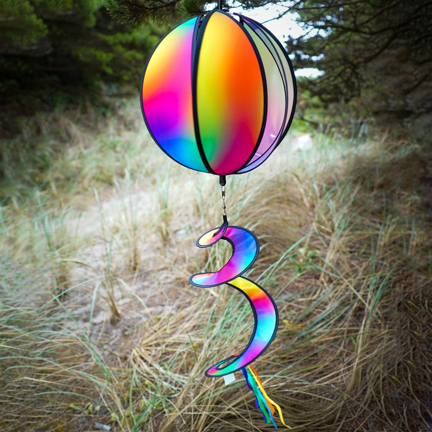 11-inch Jewel Hanging Ball Spinner with blended jewel design spinning in a garden, featuring six colorful panels and a 30-inch curlie tail.