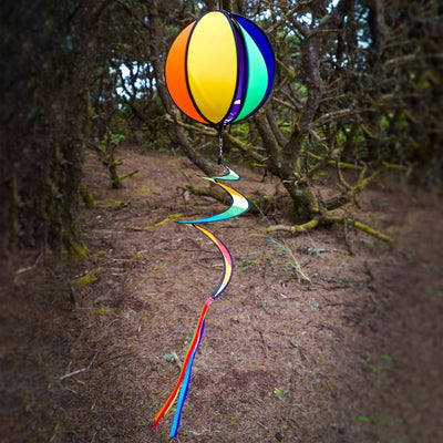 Colorful 11-inch Rainbow-Panel Hanging Ball Spinner displaying six vibrant panels and a curly tail, spinning in the garden under outdoor sunlight.