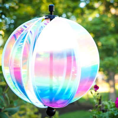 An 11" striped iridescent gazing ball displayed in a garden, featuring colorful reflections and a durable pole for stability.