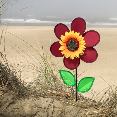 12" burgundy sunflower spinner in vibrant colors with spinning petals displayed in a garden setting, enhancing outdoor decor.