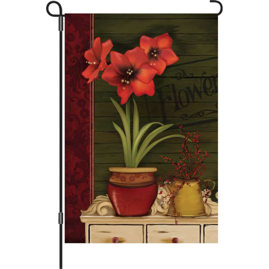 12 in. Amaryllis garden flag featuring vibrant floral design, displayed outdoors in a garden setting, adding autumn charm to the landscape.