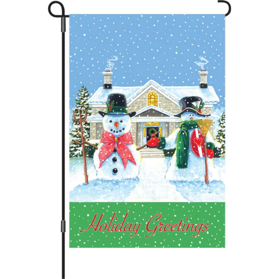 12 in. American Snowman garden flag featuring a cheerful snowman and holiday greetings, displayed outdoors in a winter setting.