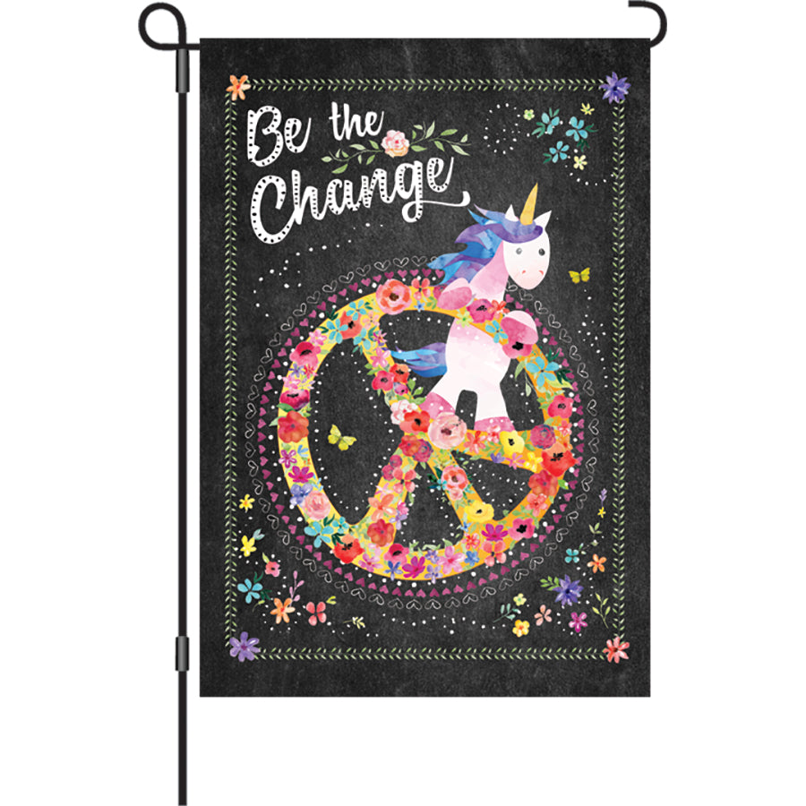 12 in. Be The Change flag featuring an inspiring message displayed outdoors in a garden setting, showcasing vibrant colors and soft fabric.