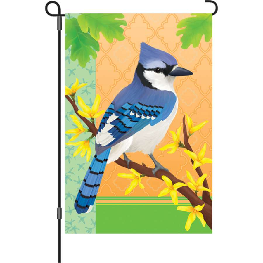 12 in. garden flag featuring a blue jay perched among spring flowers, displaying vivid colors and top-stitching detail in an outdoor setting.