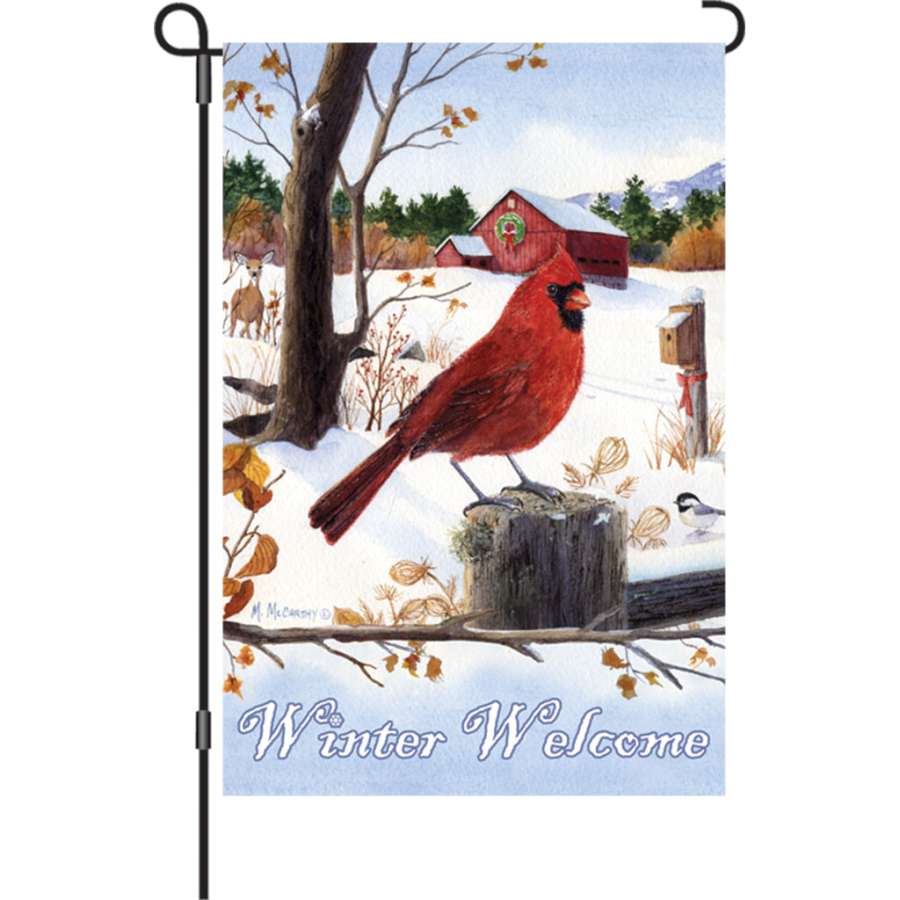 12 in. Cardinal Morning garden flag featuring vibrant cardinal design on a lush winter background, displayed outdoors in a garden setting.